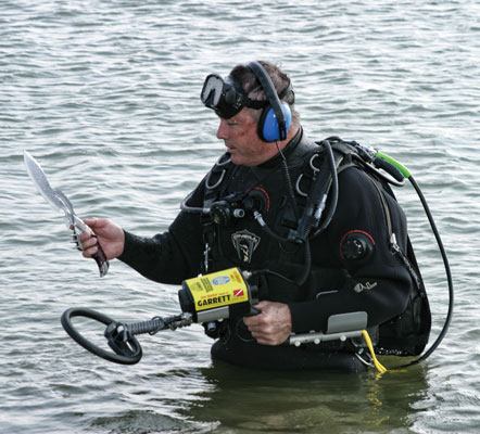 Diver recovers weapons from lake.