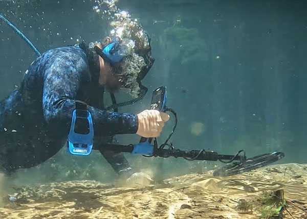 Suba diver underwater scanning with a Garrett Vortex metal detector.