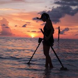 La youtubera She Detector buscando en una costa de Florida al atardecer con su AT Max.